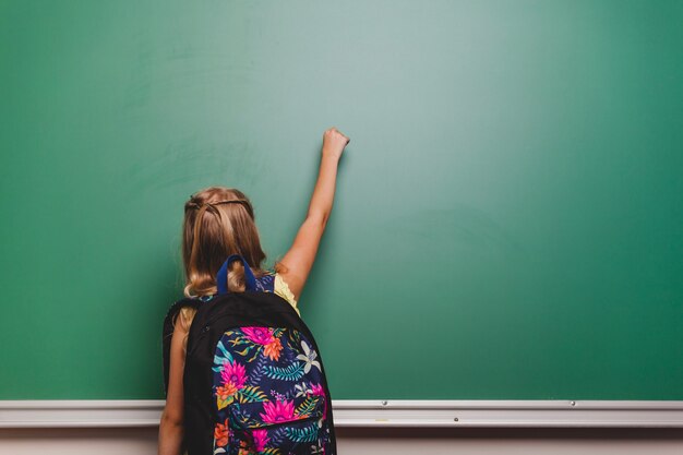 Schoolgirl writing on blackboard