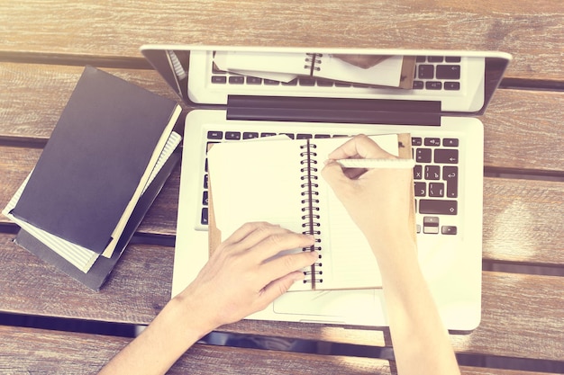 Schoolgirl wrote in a diary with books and laptop