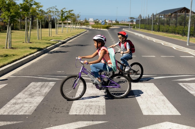 Photo schoolgirls crossing the road with bicycles