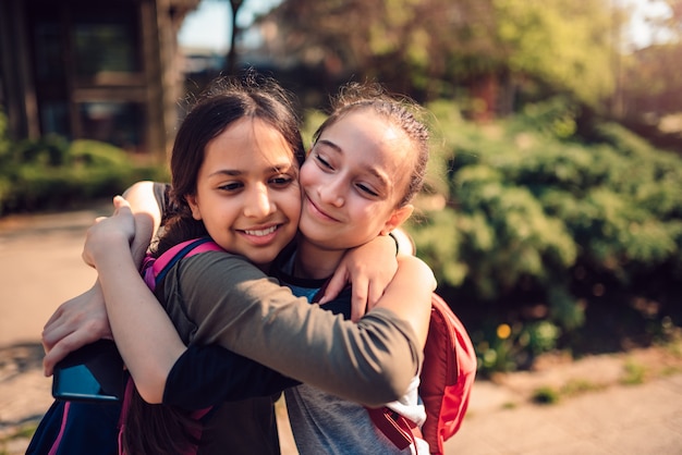 Foto studentesse che abbracciano un primo giorno di scuola