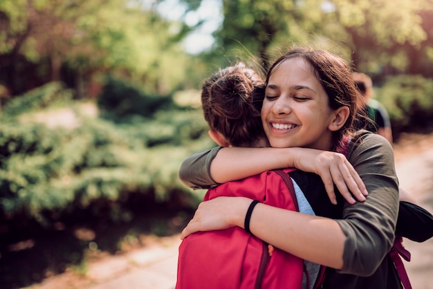 Schoolgirls hugging on first day of school