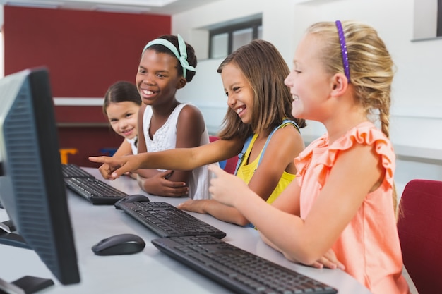 Schoolgirls using computer in classroom