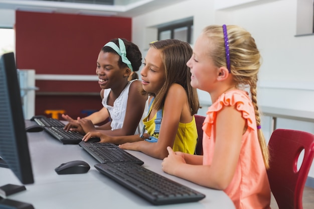 Photo schoolgirls using computer in classroom