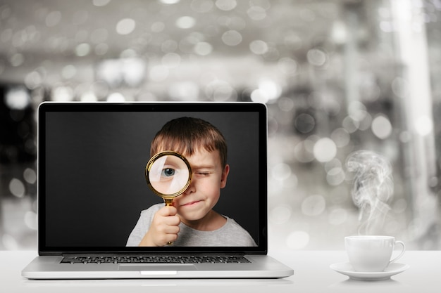 Schooling online via laptop computer at home. Face of boy in monitor computer