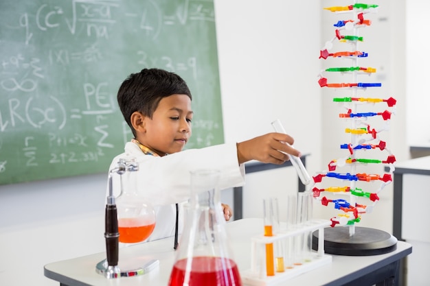 Schooljongen die een chemisch experiment in laboratorium doet