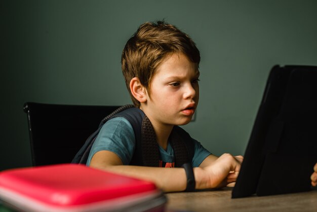 Schooljongen die thuis tablet speelt, opgroeit met technologie