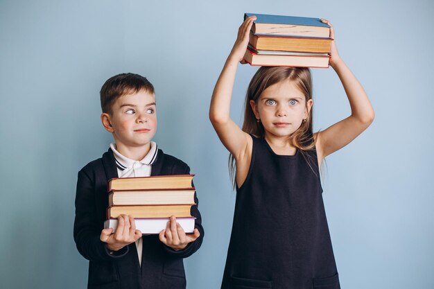 Schooljongen en schoolmeisje dragen uniform en houden boeken vast