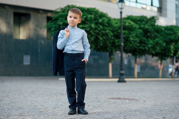 Schooljongen het stellen in formele slijtage, elegante kleren