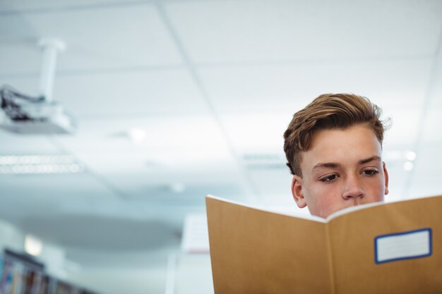 Schooljongen leesboek in bibliotheek