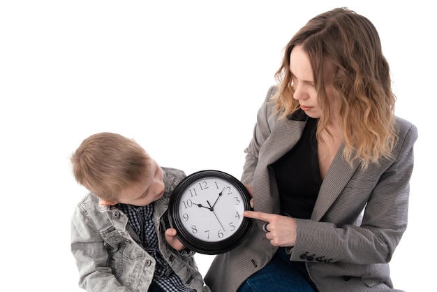 Schooljongen moeder en zoon studeren de klok Geïsoleerd op witte achtergrond Time management tijd voor interactie tussen ouder en kind concept