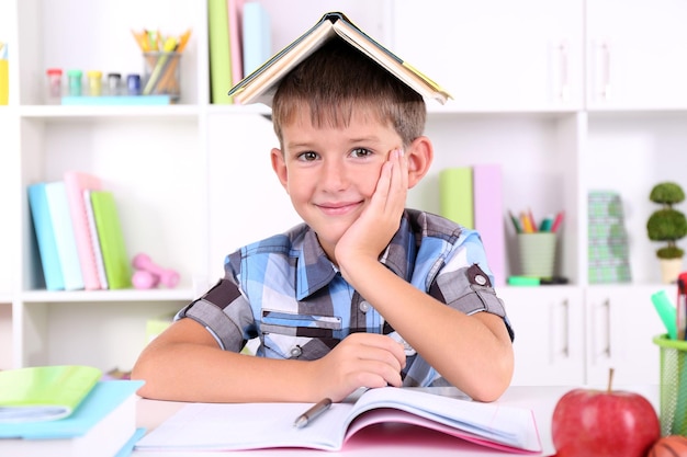 Schooljongen zittend aan tafel in de klas