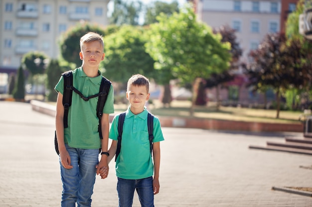 Schooljongens met rugzakken naar school gaan. Kinderen en onderwijs in de stad.