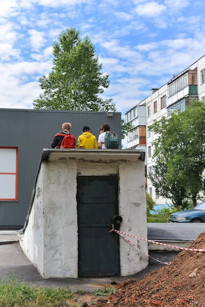 schooljongens zitten op het dak bij de bouwplaats