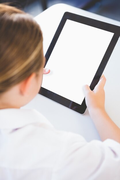 Schoolkid using digital tablet in classroom