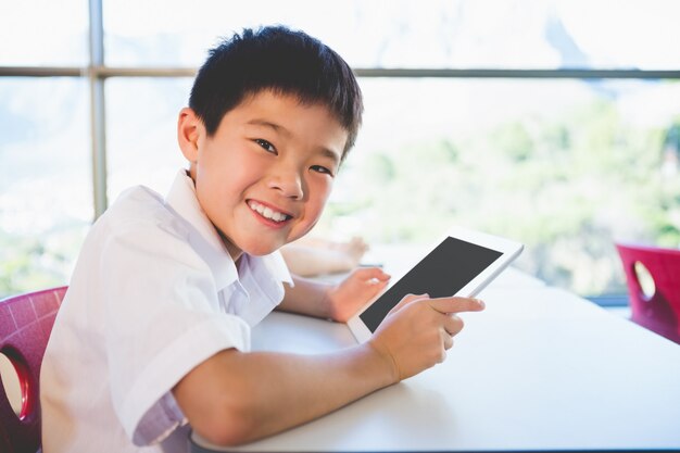 Schoolkid с использованием цифрового планшета в классе