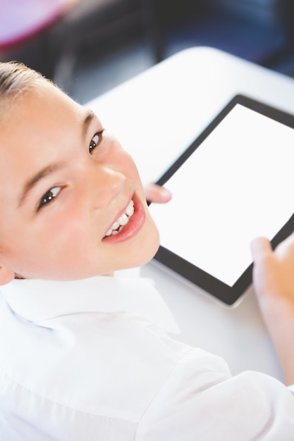 Schoolkid using digital tablet in classroom