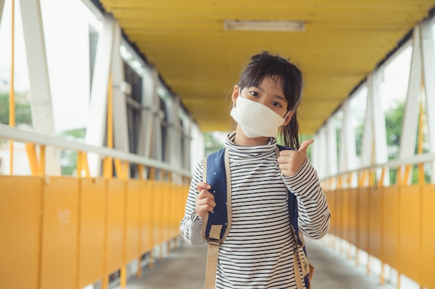 Schoolkind dat een gezichtsmasker draagt tijdens coronavirus en griepuitbraak