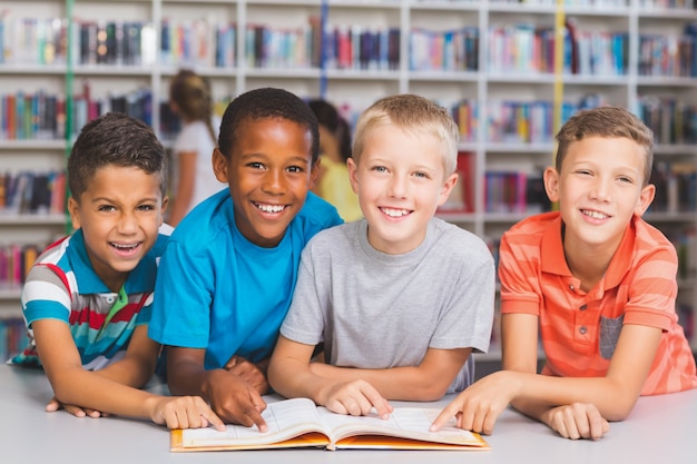 Schoolkinderen die boek samen in bibliotheek lezen