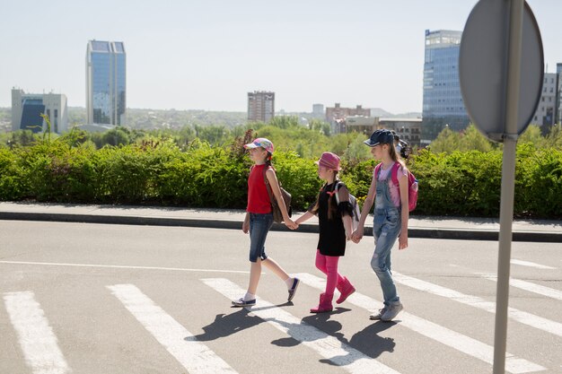 Schoolkinderen die de weg oversteken op weg naar school