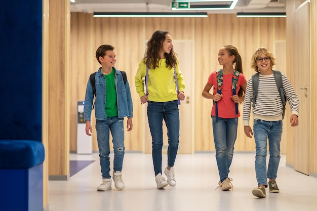 Schoolkinderen die met rugzakken in gang lopen