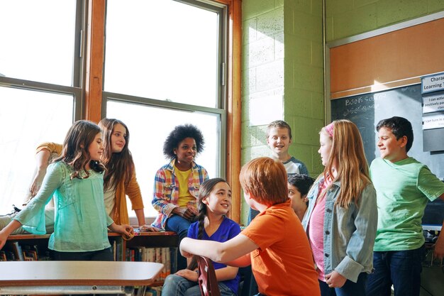 Foto schoolkinderen en studenten die in een klaslokaal praten om te leren en te studeren voor kennis en onderwijs diversiteitsjongen en -meisjesgroep in de klas leren voor toekomstige ontwikkeling en groei ter discussie