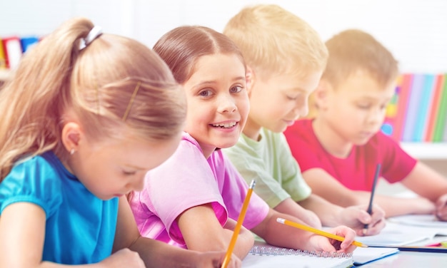 Schoolkinderen in de klas schrijven, tekenen