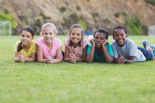 Schoolkinderen liggend op de speelplaats