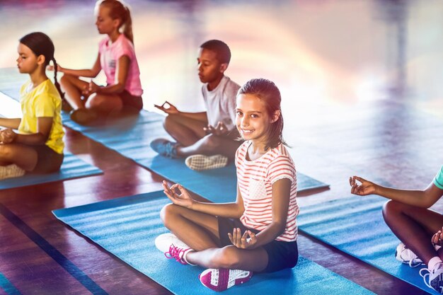 Foto schoolkinderen mediteren tijdens yogales