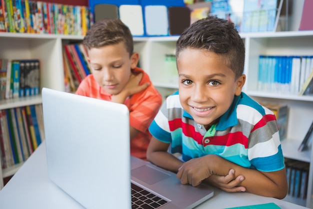 Schoolkinderen met behulp van een laptop in de bibliotheek