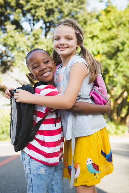 Schoolkinderen omhelzen elkaar op de campus