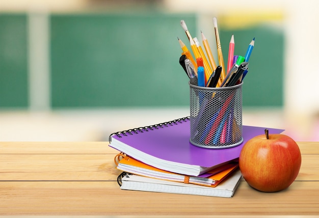 Schoollerarenbureau met stapel boeken en appel