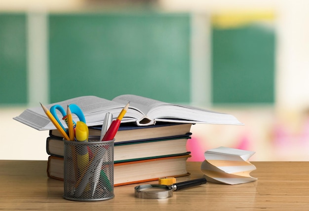 Schoollerarenbureau met stapel boeken en appel
