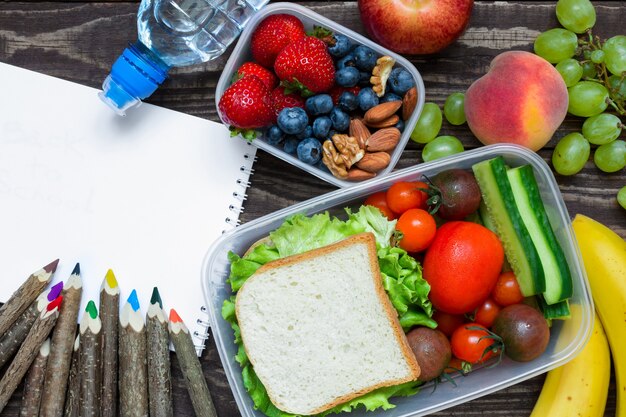 Foto schoollunchdozen met sandwich, vers fruit en groenten