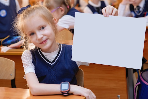 Schoolmeisje aan haar bureau in de klas tijdens de les