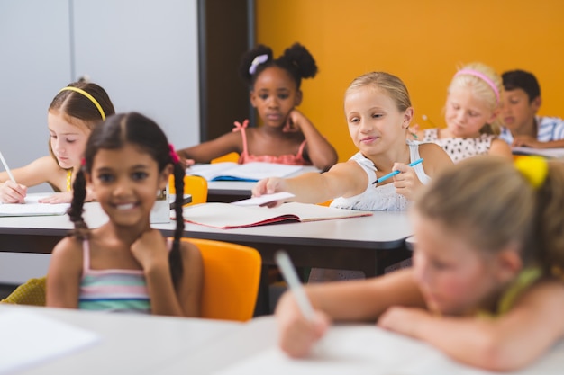 Foto schoolmeisje chit geven aan haar vrienden in de klas