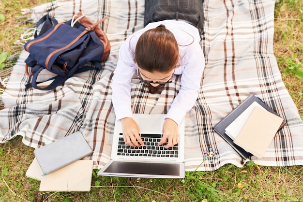 Schoolmeisje dat huiswerk in openlucht doet