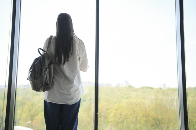 Schoolmeisje dat zich met boeken en rugzak op school bevindt