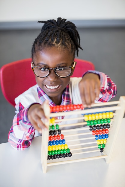 Schoolmeisje die een wiskundetraam gebruiken op school