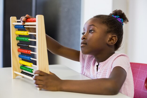 Schoolmeisje die een wiskundetraam in klaslokaal gebruiken