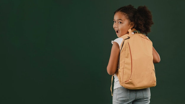 Schoolmeisje en haar rugzak kopiëren ruimte