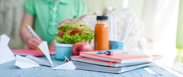 Schoolmeisje en lunch. Boeken en schriften voor school.