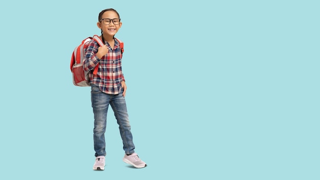 Schoolmeisje Gelukkig lachend Aziatisch student schoolkind draagt een bril met draagtas Volledig lichaamsportret geïsoleerd op pastel effen lichtblauwe achtergrond