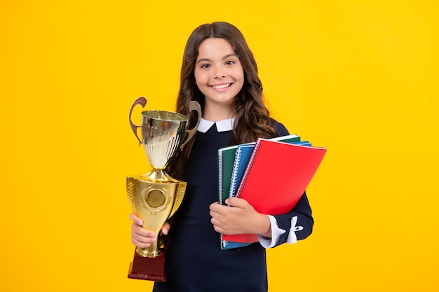 Schoolmeisje in schooluniform overwinning vieren met trofee Tiener met winnende prijs