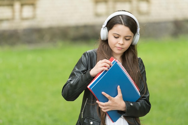 Schoolmeisje luistert naar audioboeken op weg naar school, gemakkelijk leerconcept.