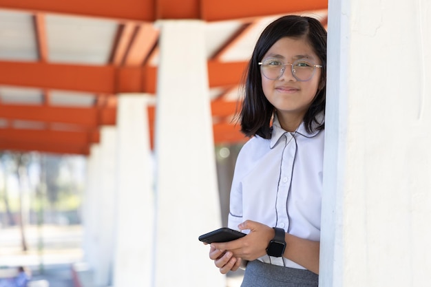 Schoolmeisje met behulp van smartphone en smartwatch op school