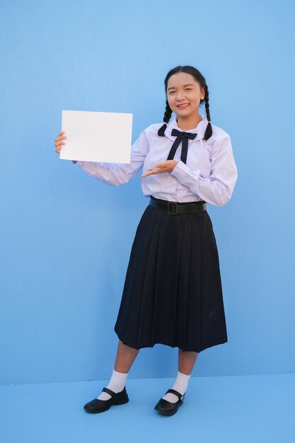 Schoolmeisje met billboard op blauwe achtergrond