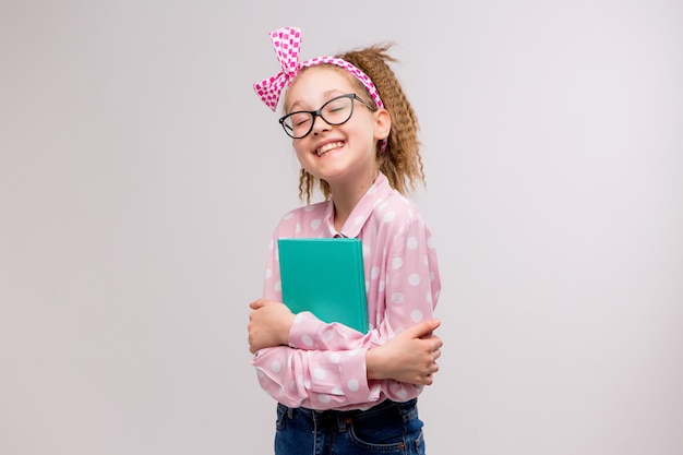 schoolmeisje met een bril met een boek glimlachen