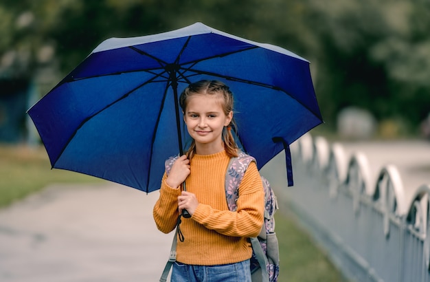 Schoolmeisje met rugzak buitenshuis