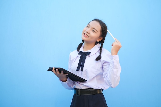 Schoolmeisje met tablet op blauwe achtergrond