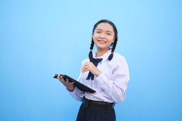 Schoolmeisje met tablet op blauwe achtergrond